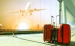 Stack Of Traveling Luggage In Airport Terminal Building And Passenger Plane Flying Over Urban Scene Stock Photo