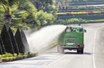 Water Truck Watering Bush In Park Stock Photo