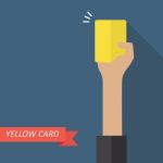 Hand Of Referee Showing Yellow Card Stock Photo