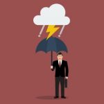 Businessman With Umbrella In Storm Stock Photo