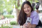 Portrait Of Thai High School Student Uniform Teen Beautiful Girl Using Her Phone And Smile Stock Photo