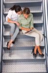 Two Women Sitting Staircase Using Digital Tablet Stock Photo