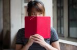 Portrait Of Thai Adult Beautiful Girl Reading Red Book Stock Photo