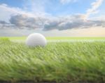 Golf Ball On Green Front Of Blur Cloud Morning Sky Stock Photo