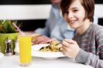 Boy Enjoying Food And Fresh Juice Stock Photo