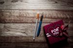 Gift Box And Pens On Wooden Plank Stock Photo