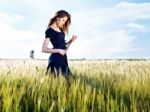 Woman At Wheat Field On Sunny Day Stock Photo