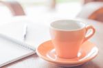 Orange Coffee Cup With Pen And Notebook Stock Photo