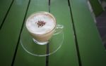 Hot Cappuccino Coffee In Glass Mug On Green Table Stock Photo