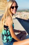 Pretty Blonde Girl Sitting On The Roof Stock Photo