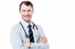 Male Doctor Standing With Folded Arms Stock Photo