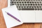 Notepad And Laptop On Wooden Table Stock Photo