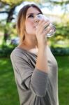 Portrait Of Beautiful Girl Drinking Water Glass At Green Park Stock Photo