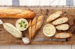 Baguette With Herb Butter And Rosemary Thyme On Rustic Wooden Background Stock Photo