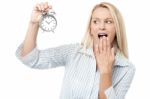 Shocked Woman Holding Alarm Clock Stock Photo