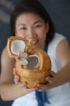 Vivacious Woman Giving A Coconut Water Stock Photo