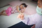 Lady Doctor Preparing An Injection For A Little Asian Girl Stock Photo