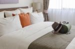 Pillows On Bed In Modern Living Room With Travel Hat And Bag Stock Photo