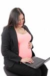 Pregnant Businesswoman Working At Laptop Stock Photo