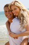 Couple Piggyback Ride At Beach Stock Photo