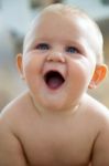 Cute Smiling Baby Sitting At Home Stock Photo