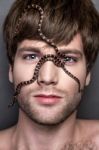 Portrait Of A Young Handsome Man With Snake On His Face Stock Photo