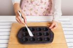 Woman Spread Oil In Baking Pan Stock Photo