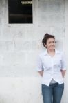 Attractive Teenage Asian Girl Standing In Front Of Grunge Concrete Wall Stock Photo