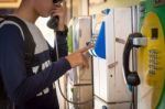 Male Tourists Are Using The Old Public Telephone Keypad Stock Photo