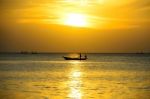 Fisherman In Sea At Sunset Stock Photo