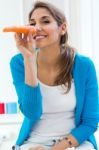 Pretty Young Woman Having Fun With A Carrot In The Kitchen Stock Photo