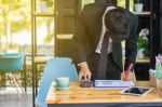 Business Man Sitting On A Calculator To Figure Out In A Coffee S Stock Photo