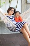 Family Relaxing Time Mother And Young Kid On White Clothes Cradl Stock Photo