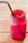 Iced Drink In Red Glass On Wooden Table Stock Photo