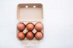 Chicken Eggs In Egg Box On White Wooden Background Stock Photo