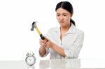 Frustrated Woman Smashing An Alarm Clock Stock Photo