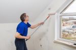 Elderly Worker Painting Wall With Glue Stock Photo