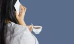 Women Hold Cup Of Coffee And Talking On Mobile Or Smartphone Stock Photo