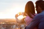 Young Couple Of Tourist In Town Using Mobile Phone Stock Photo