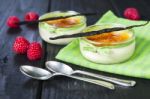 The Creme Brulee In Glass Dish With Vanilla Pods And Raspberries Stock Photo