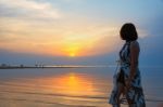 Woman Watching Sunset At The Beach Stock Photo