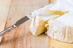 Camembert Cheese With Cut Wedge And Vintage Knife On Wooden Tabl Stock Photo