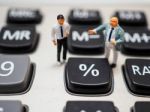 Miniature Businessman Standing On Calculator And Thinking Of Per Stock Photo