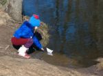 Little Girl Playing With Paper Boat On The River Stock Photo