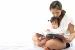 Mother Is Reading A Book For Her Baby Stock Photo