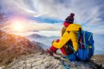 Young Woman Sitting On The Hill Of High Mountains Stock Photo