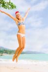 Young Blonde Woman In Bikini And Christmas Santa Hat Jumping On Stock Photo