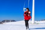 Young Woman Is A Happiness With Camera In Winter Of Sky And Winter Road With Snow And Red Dress Stock Photo