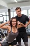 Woman With Personal Trainer  In Gym Stock Photo