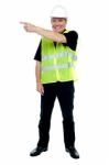 Cheerful Estate Engineer Indicating Sideways Stock Photo